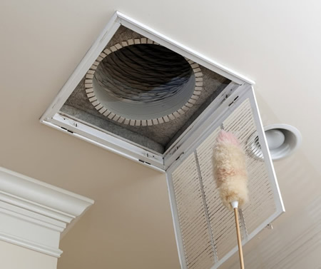 Technician cleaning a supply vent in a woodstock ga home